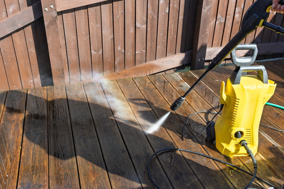 Spring cleaning domestic garden wooden decking with water jet high pressure washer