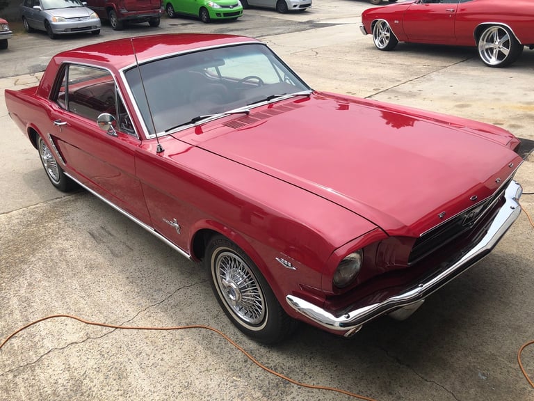 Red vintage Ford Mustang coupe at a car show