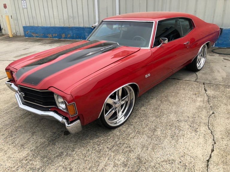 Red Chevrolet Chevelle SS muscle car with black racing stripes