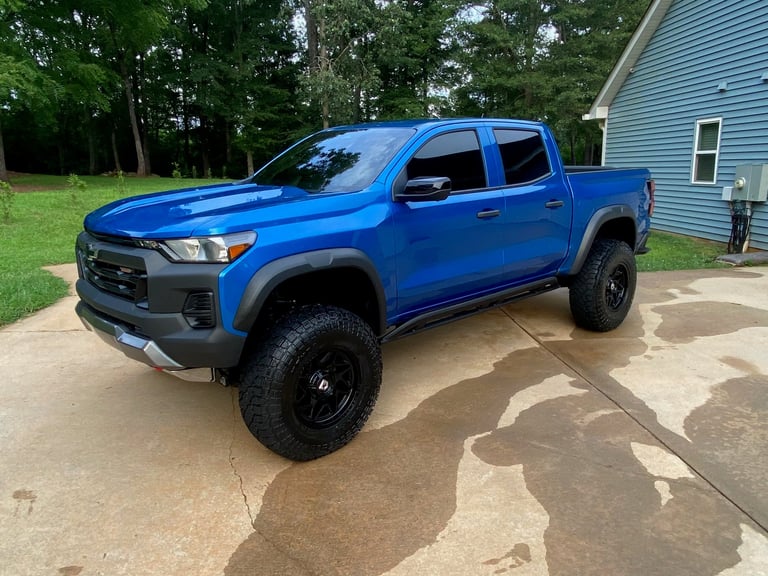 Blue Chevrolet pickup truck with black wheels on driveway