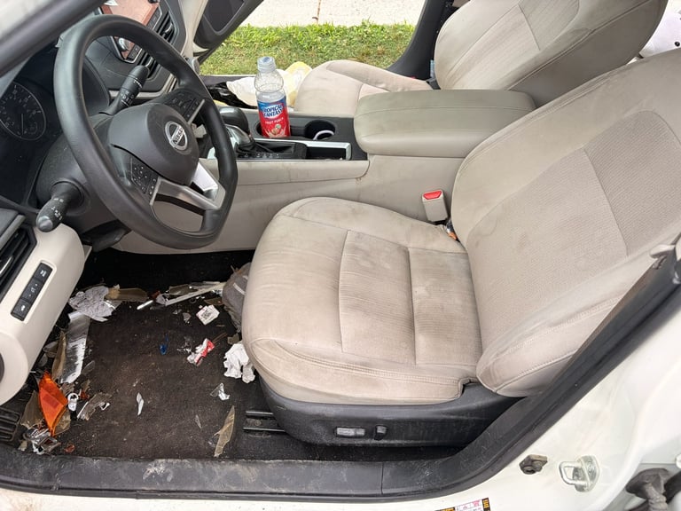 Dirty car interior with debris on floor