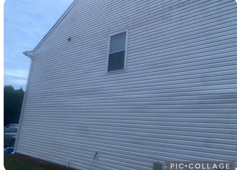 Modern white metal sided house exterior with single rectangular window and angled roof against blue sky