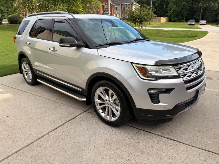White Ford Explorer SUV parked in driveway in front of house