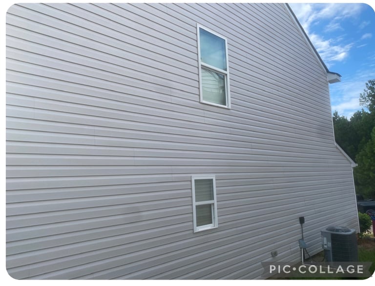 Gray horizontal siding on residential house exterior with two windows and blue sky visible