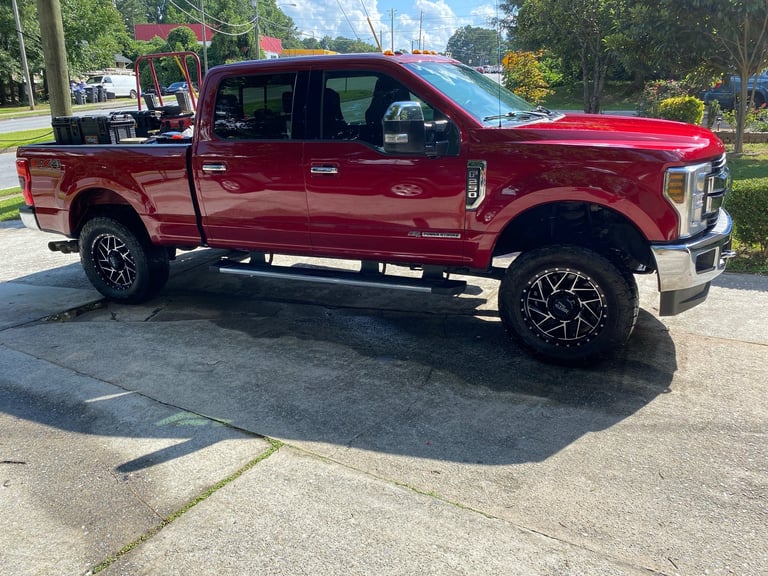 Red Ford F-250 pickup truck parked on street